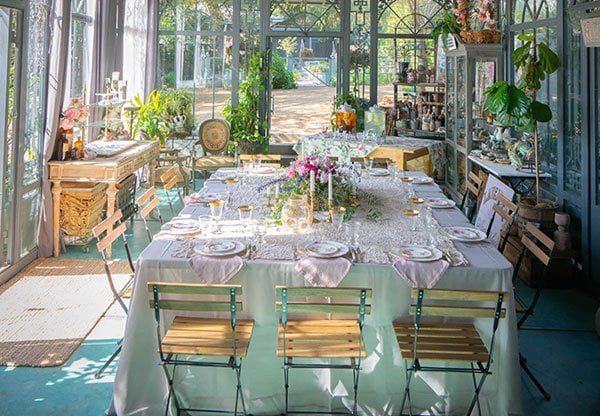 Indoor-outdoor dining area inside a glass conservatory