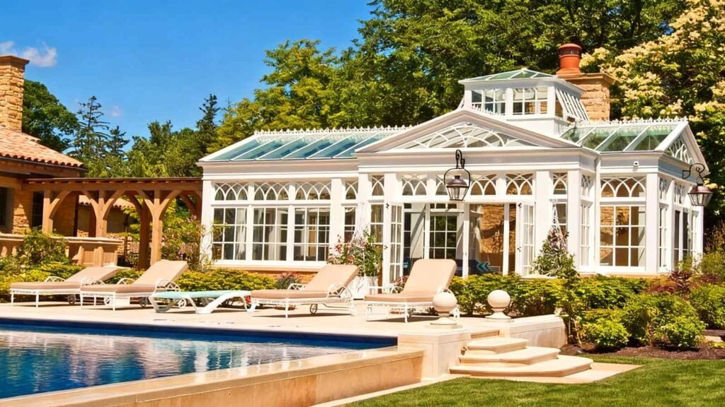 Poolside Conservatory -- elegant iron-frame lounge structure beside a swimming pool