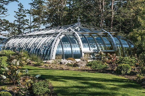 A crystal-clear enclosed pool free of leaves and debris under an iron-frame glass roof