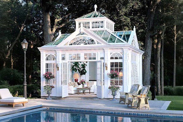 An elegant bespoke pool conservatory attached to a luxury residential property